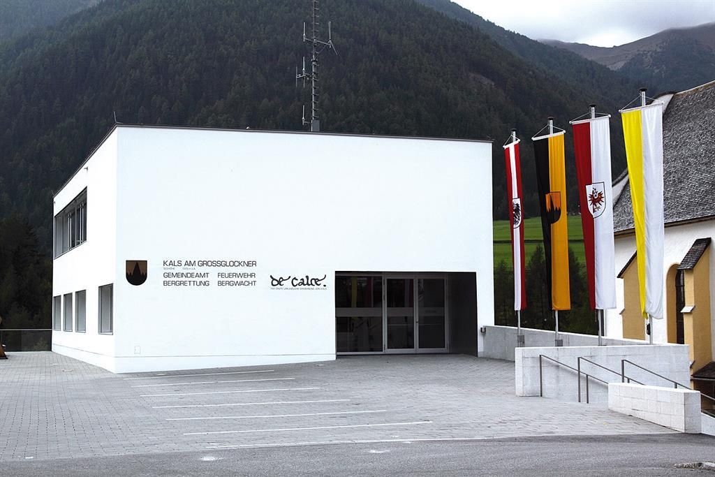 Modernes Gemeindegebäude in Kals am Großglockner, Österreich, mit Fahnen und einer Bergkulisse