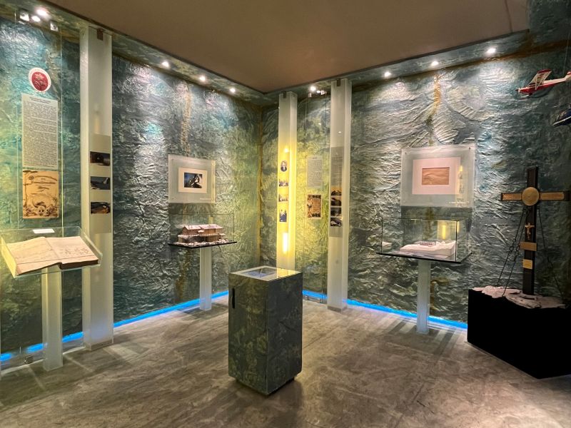 Ein unregelmäßig geformter Stein mit einem hohlen Kern, der auf einem Ständer vor einem verschwommenen Texthintergrund ausgestellt ist.