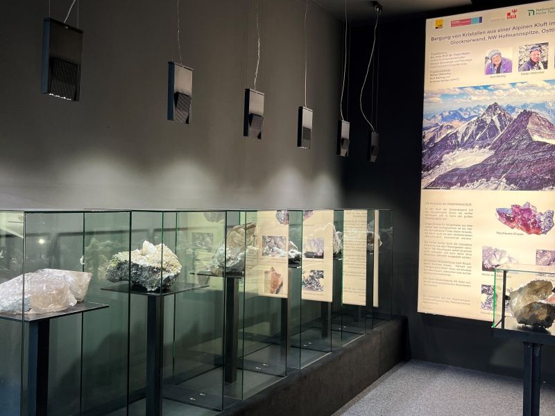 Ein unregelmäßig geformter Stein mit einem hohlen Kern, der auf einem Ständer vor einem verschwommenen Texthintergrund ausgestellt ist.