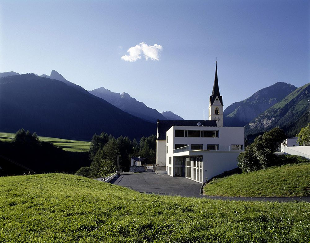 Gemeindeamt im Hintergrund die Kirche, blauer Himmel 